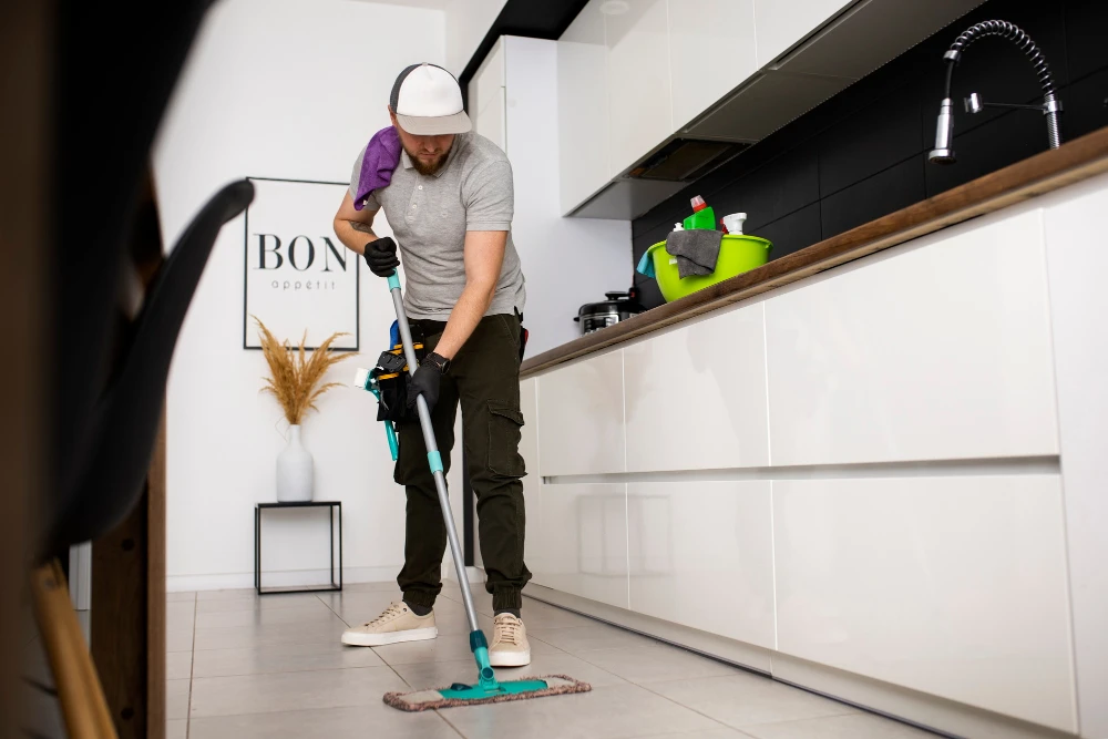 Residential or office cleaner mopping a modern kitchen floor.
