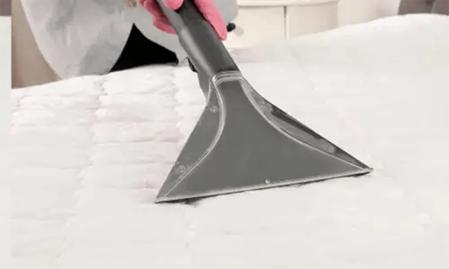After-2 Steam cleaning wand lifting stains from a white fabric mattress surface.