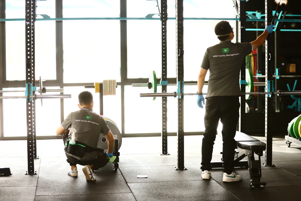 Wide shot of a fitness center undergoing daily janitorial floor maintenance.