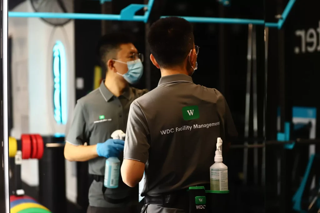 Commercial cleaning supervisors discussing site operations and safety in a gym environment.