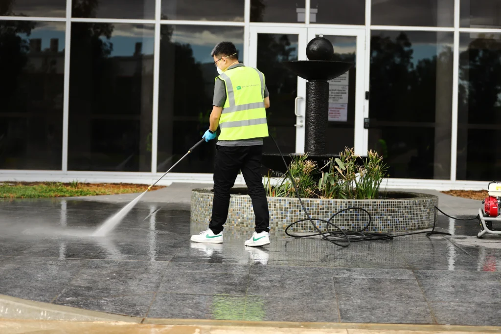 High-pressure washing service removing grime from outdoor commercial pavement.