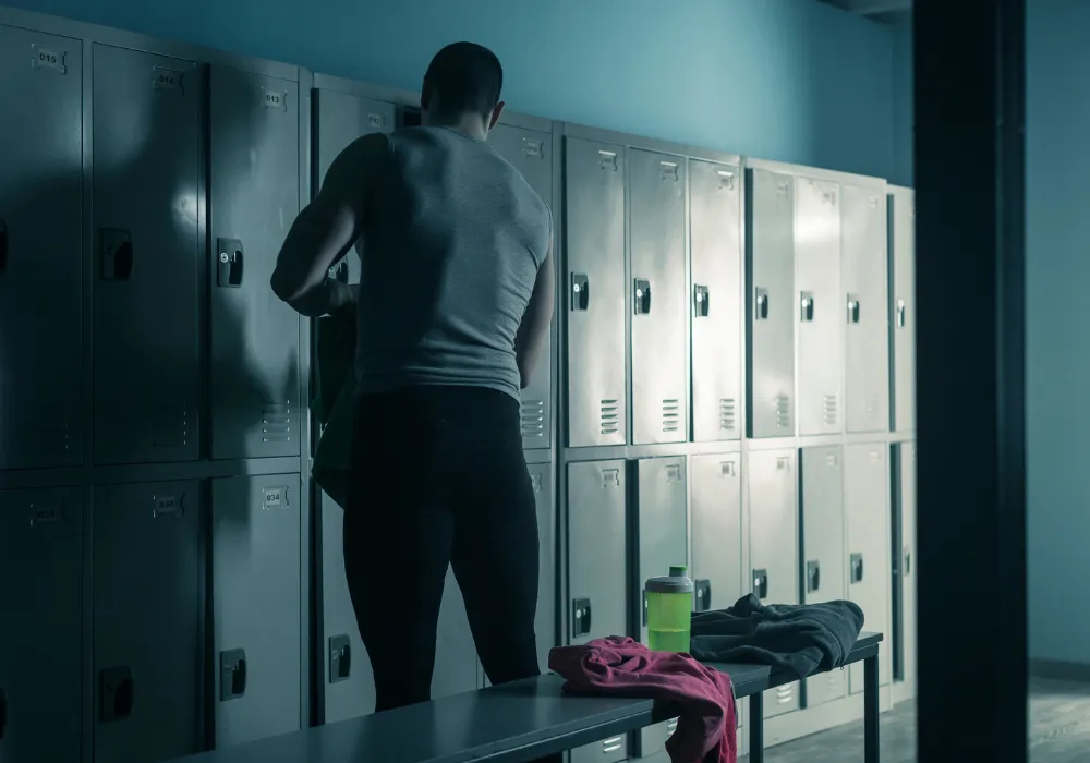 Man using a clean and sanitized locker room facility in a commercial gym.