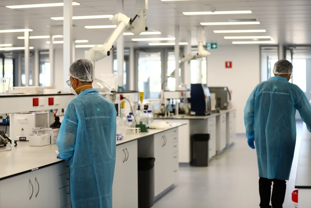 Lab technician in blue gown maintaining sterile conditions in a medical facility.