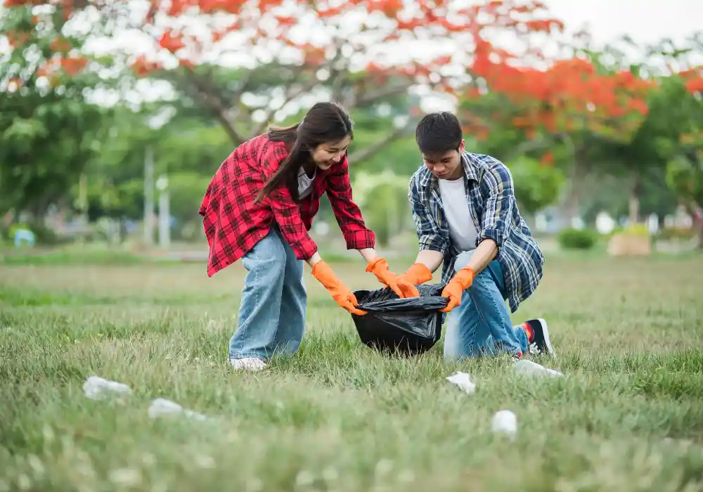 Grounds maintenance team picking up litter and debris from a park or campus lawn.