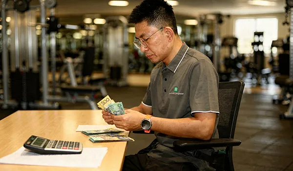Gym management staff handling administrative tasks and financial planning at a clean workstation.